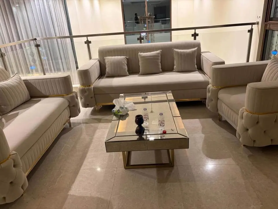 Beige majlis sofa set with armchairs and a mirrored coffee table bought as one lot in Dubai